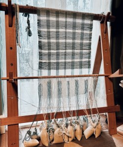 This photo shows how the weaving has progressed. The warp-beam has been unwound and the weights at the bottom are slack. There's about 12 inches of woven fabric. 