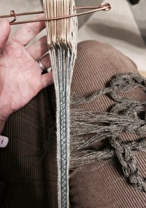 Photo showing a tablet woven band with the weft threads chained up to become the warp on the warp-weighted loom.